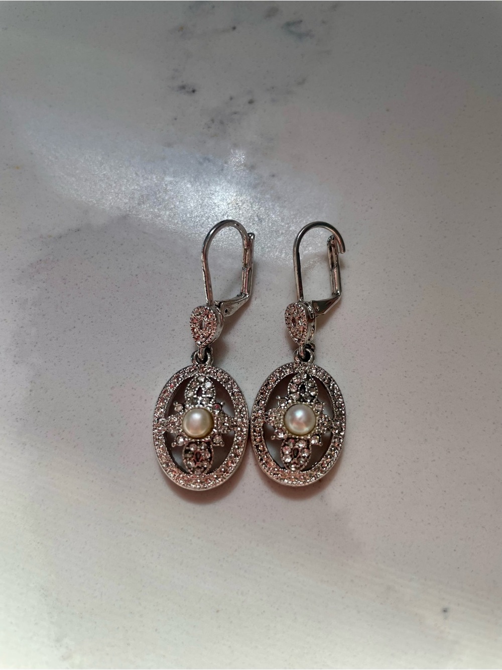 Vintage silver-tone oval drop earring featuring a central round pearl